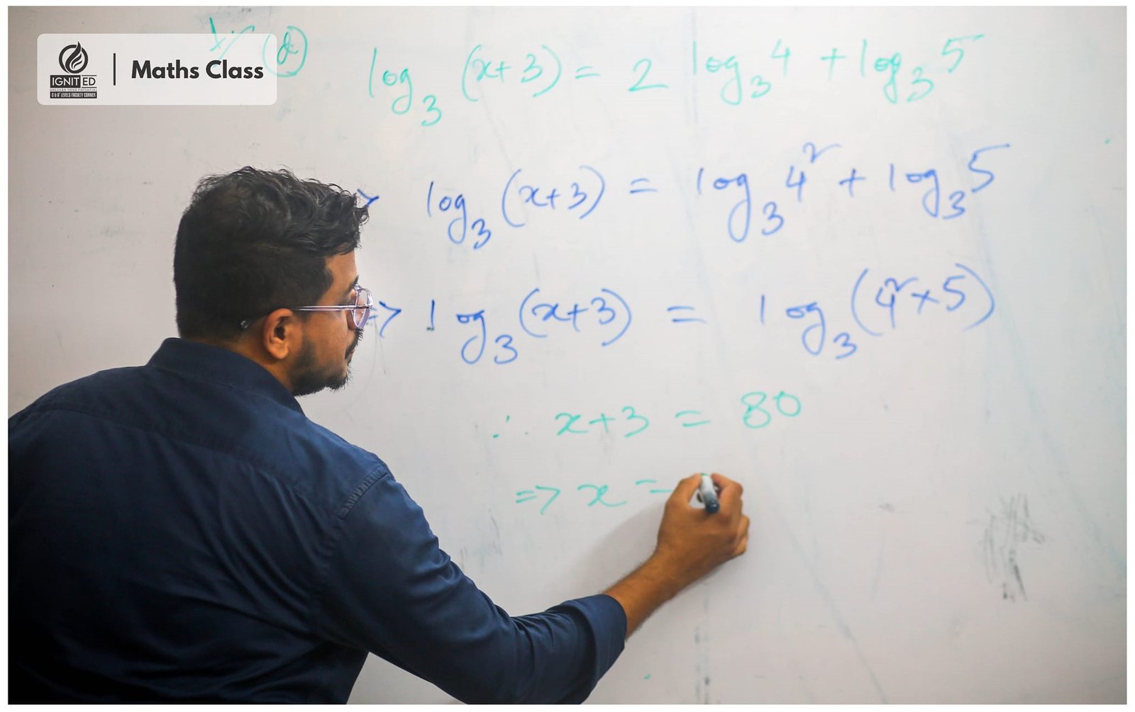 Tutor solving a logarithmic equation on the whiteboard during an A Level Maths class
